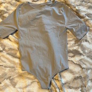 Silver short sleeved bodysuit. Never worn. Size m/l
